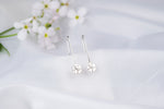 Load image into Gallery viewer, Silver earrings with floral designs on a light background
