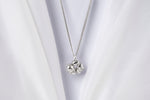Load image into Gallery viewer, Silver necklace pendant on a white fabric background
