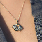 Load image into Gallery viewer, A close-up image of a person's neck wearing a silver necklace with a rock-like pendant.
